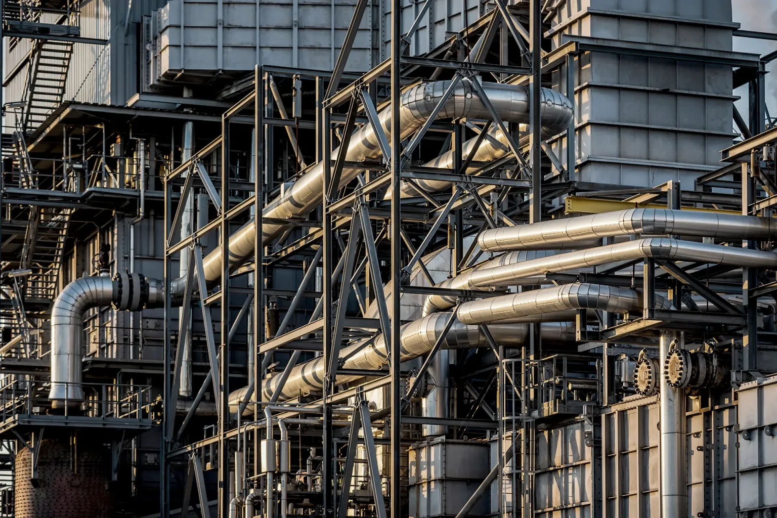 Komplex industriell struktur med metallrör, stålbalkar och byggnadsställningar